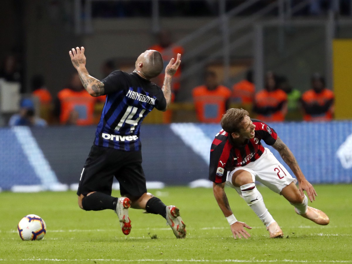 Radja Nainggolan (vľavo) z Interu Miláno padá po faule Lucasa Bigliu z AC Milána