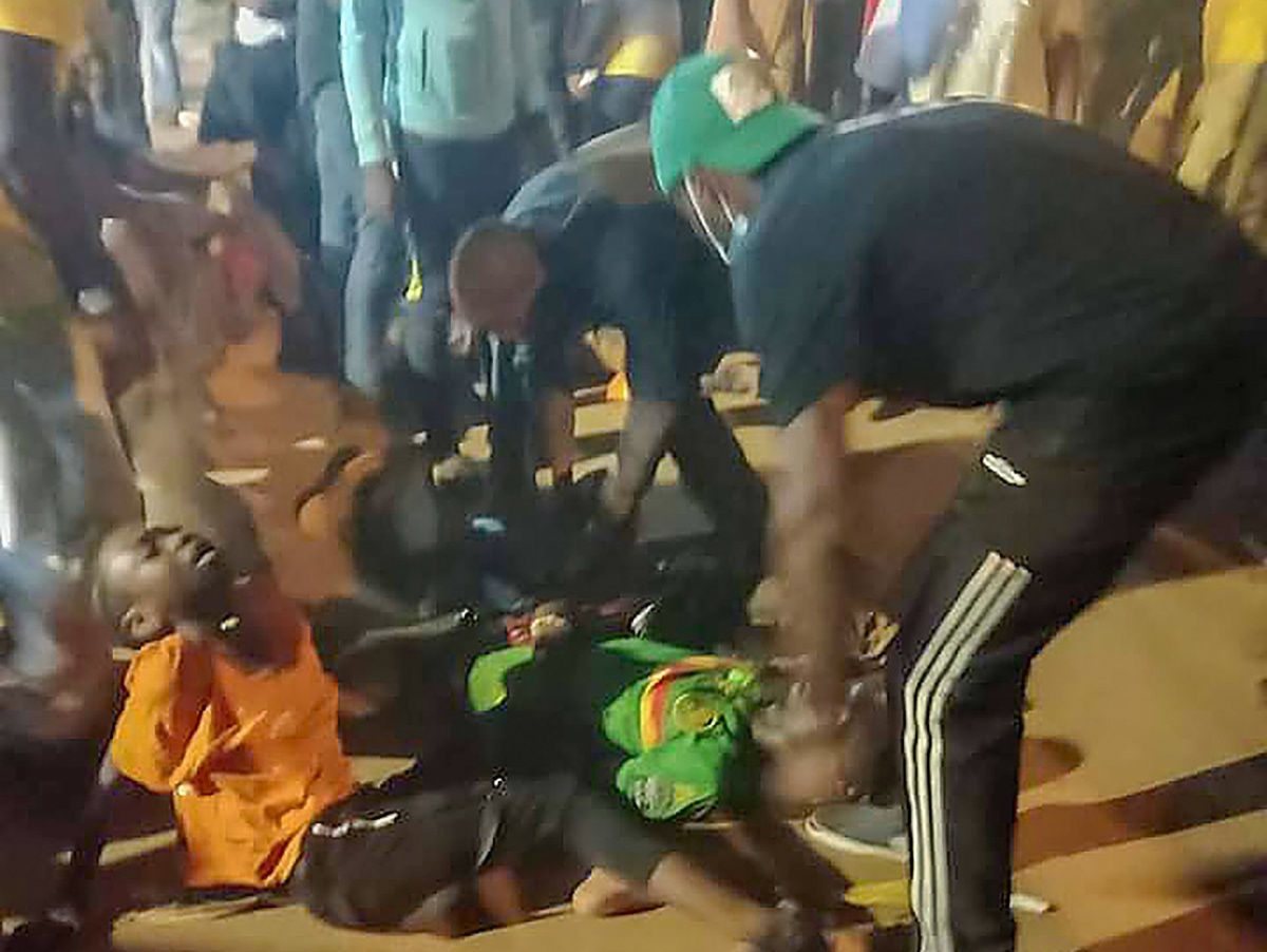 Ľudia pomáhajú zraneným osobám po tlačenici, ku ktorej došlo  pred futbalovým štadiónom pred začiatkom osemfinálového zápasu Kamerun - Komory na Africkom poháre národov v kamerunskej metropole Yaoundé
