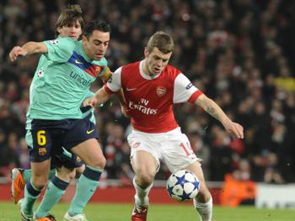 Jack Wilshere bojuje o loptu s Xavim
