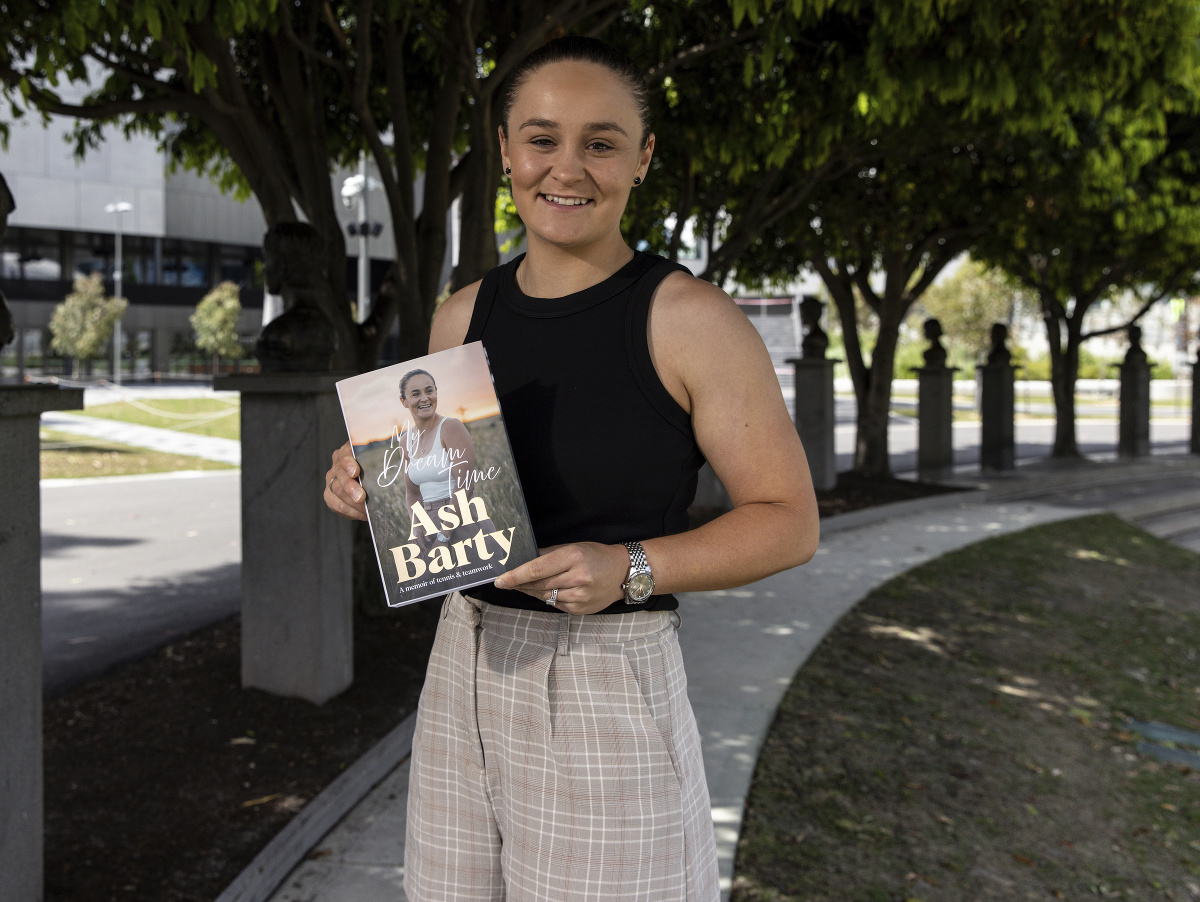 Bývalá austrálska tenistka Ash Bartyová pózuje s knihou počas predstavenia jej novej knihy 