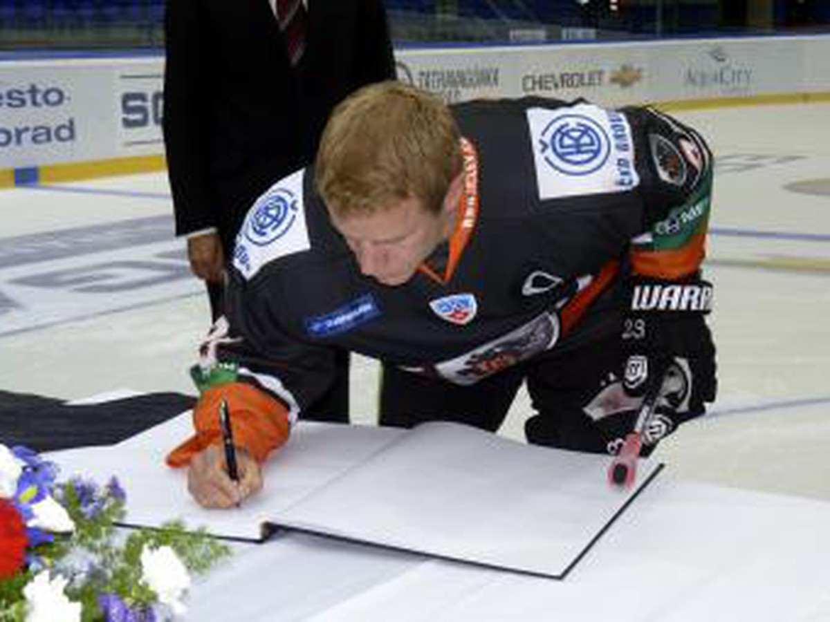 Ľuboš Bartečko sa podpisuje do kondolenčnej knihy počas pietnej spomienky za zosnulého hokejistu Pavla Demitru a  obete stredajšej leteckej tragédie v Jaroslavli