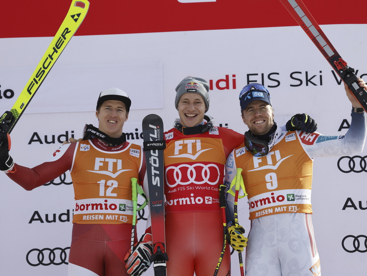 Švajčiarsky lyžiar Marco Odermatt (uprostred) sa raduje na pódiu z víťazstva v super-G Svetového pohára v alpskom lyžovaní v talianskom Bormiu 29. decembra 2023. Na druhom mieste skončil Rakúšan Raphael Haaser (vľavo) a tretí sa umiestnil Nór Aleksander A