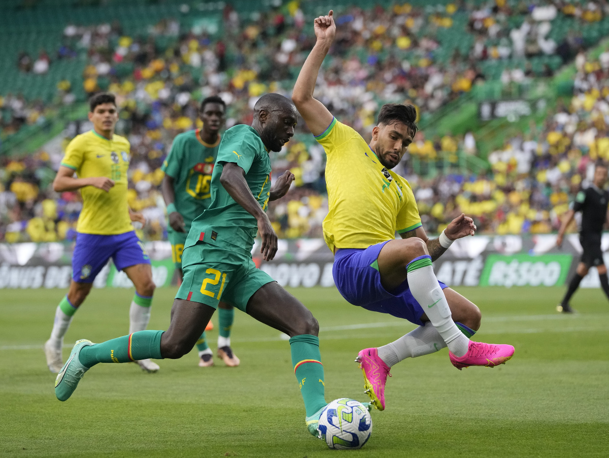 Lucas Paqueta sa snaží zblokovať pokus Youssoufa Sabalyho počas prípravného zápasu Brazília - Senegal