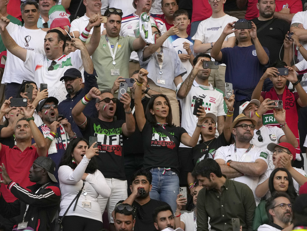 Iránski fanúšikovia s palcami dole počas národnej hymny Iránu pred súbojom s Anglickom