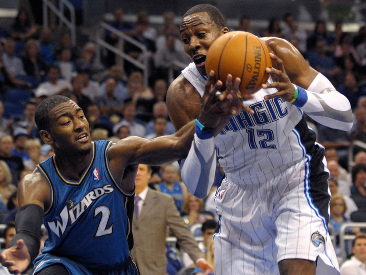 Dwight Howard (s loptou) faulovaný Johnom Wallom