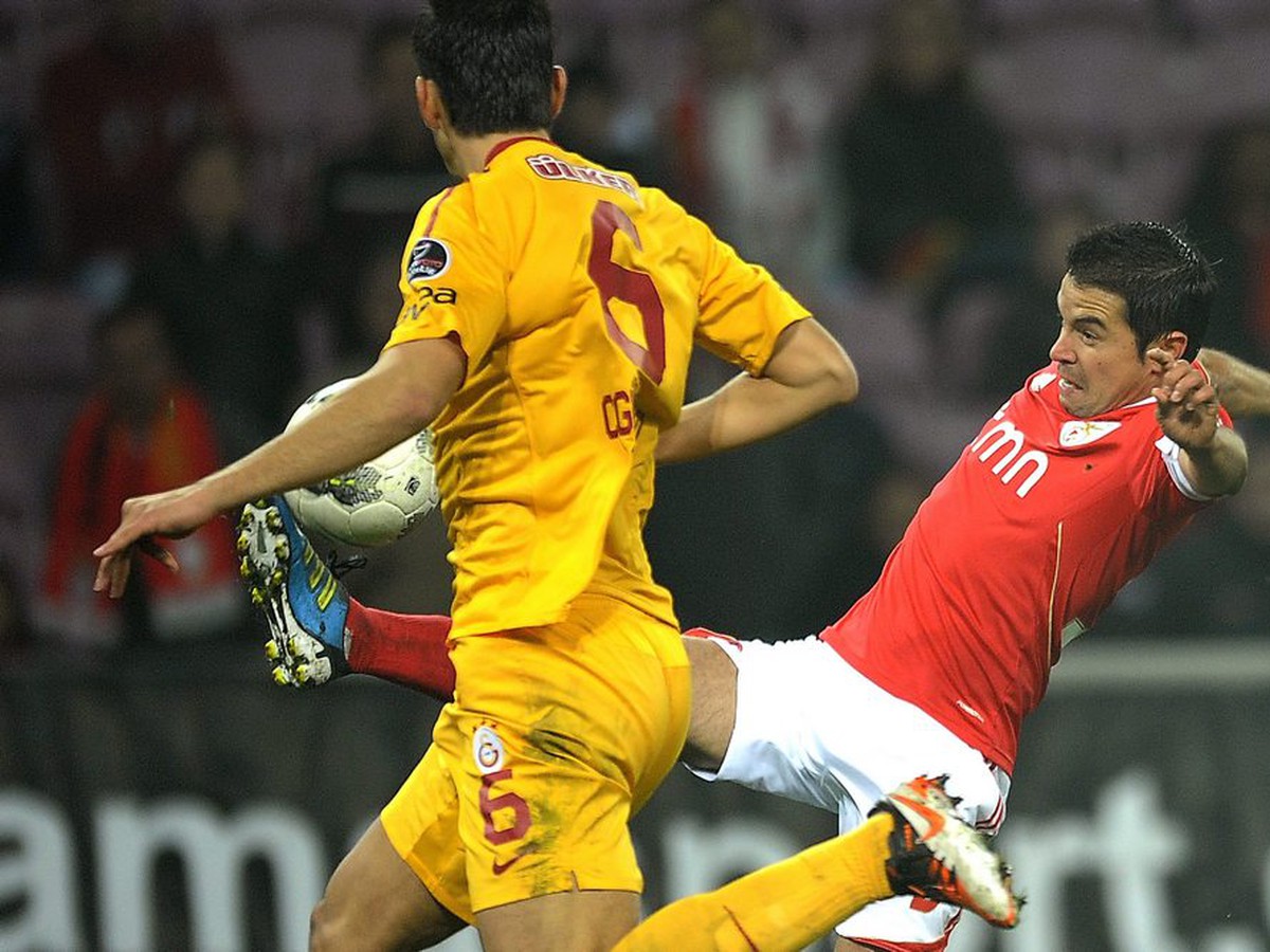 Ceyhun Gulselam z Galatasarayu (v žltom) v súboji o loptu s hráčom Benfiky Javierom Saviolom v priateľskom stretnutí vo švajčiarskej Ženeve (12.11.)