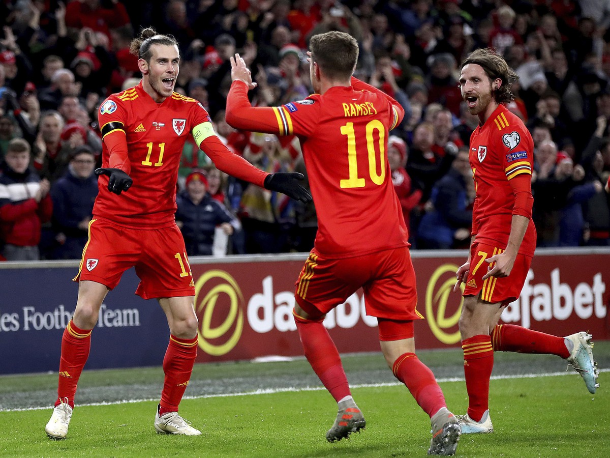  Na snímke v strede hráč Walesu Aaron Ramsey oslavuje so spoluhráčmi Garethom Baleom (vľavo) a Joe Allenom (vpravo) svoj úvodný gól v zápase 10. kola E-skupiny kvalifikácie na EURO 2020 Wales - Maďarsko