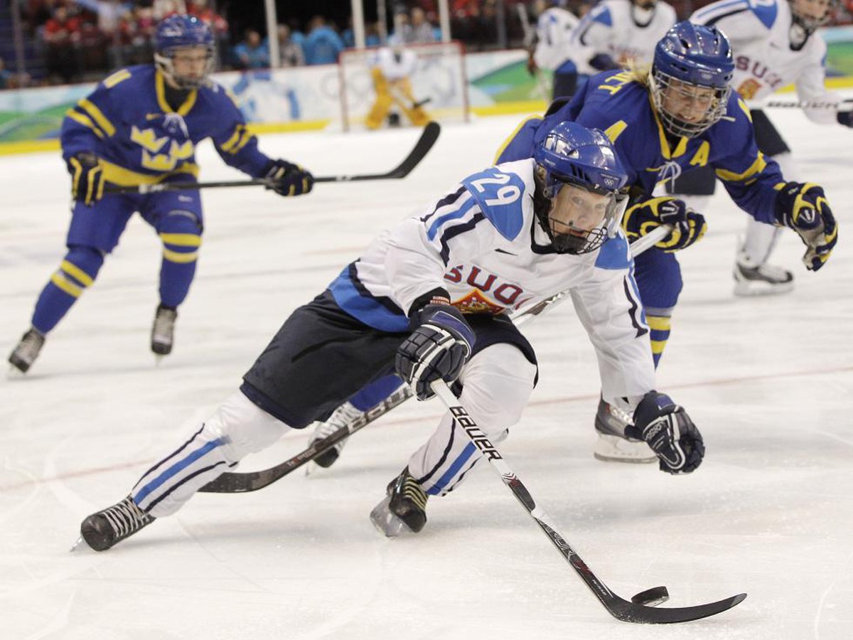 Fínska hokejistka  Karolina Rantamakiová v súboji o puk so Švédkou Jenni Asserholtovou