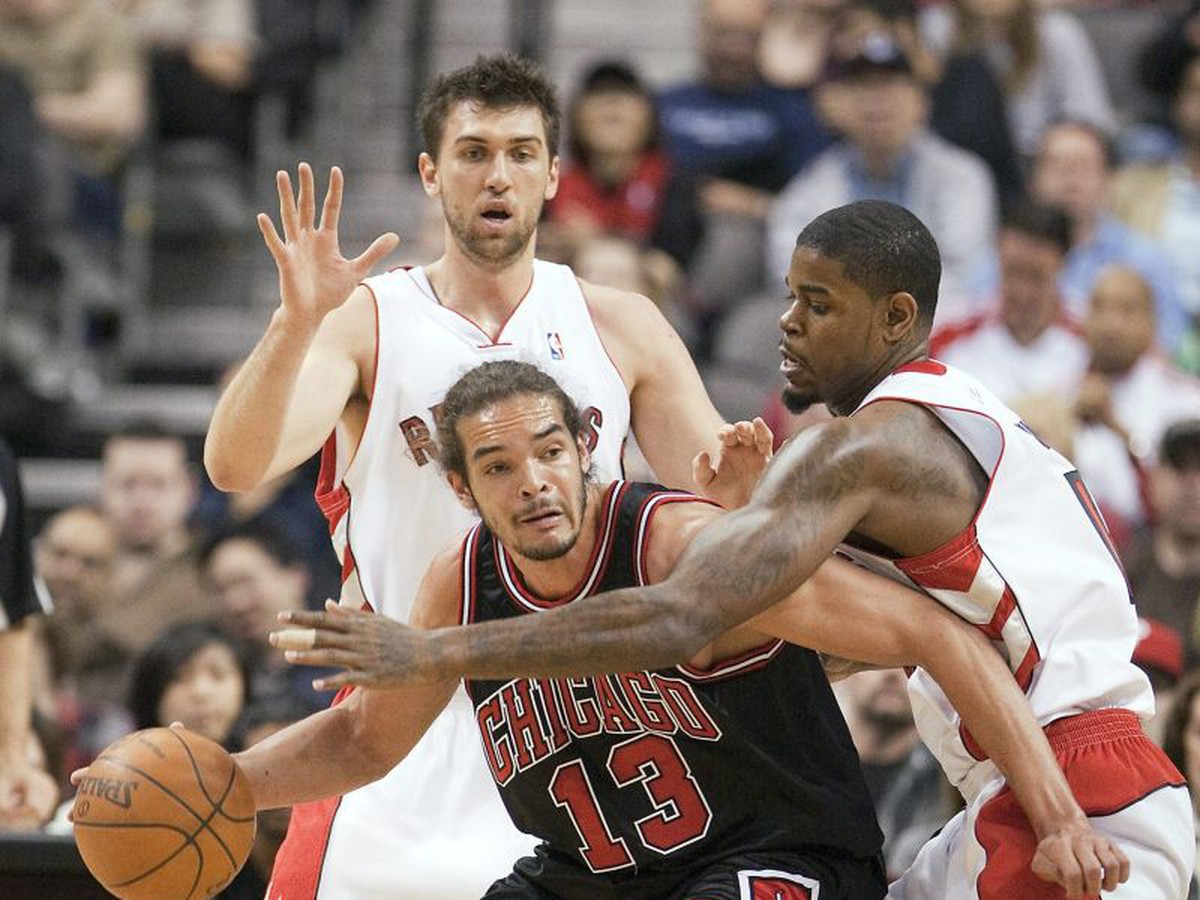 Joakim Noah bránený hráčmi Toronta