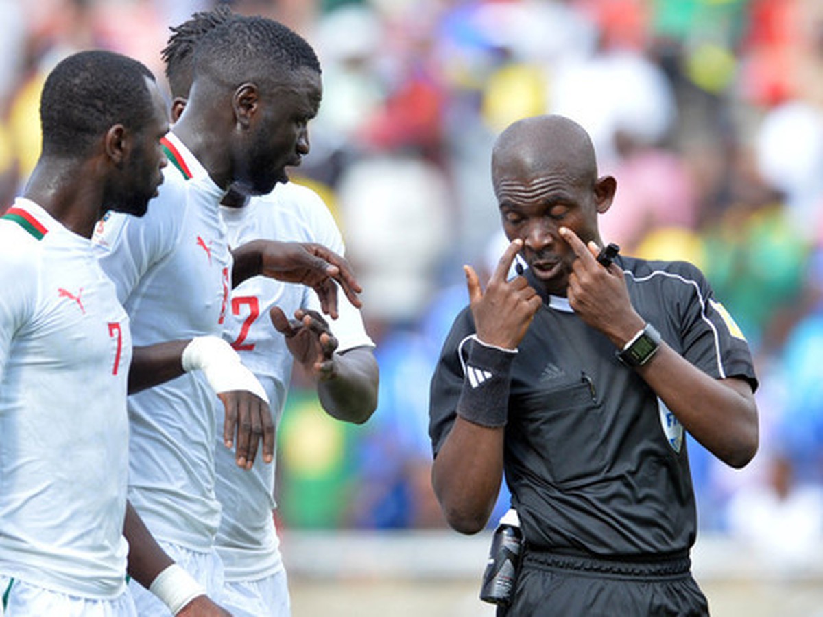 Ghanský rozhodca Joseph Lamptey v diskusii s poškodenými hráčmi Senegalu