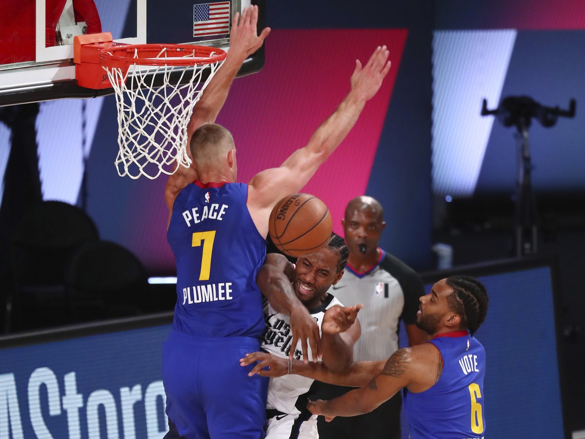 Hráč Los Angeles Clippers Kawhi Leonard (uprostred) sa pokúša strieľať cez Masona Plumleeho