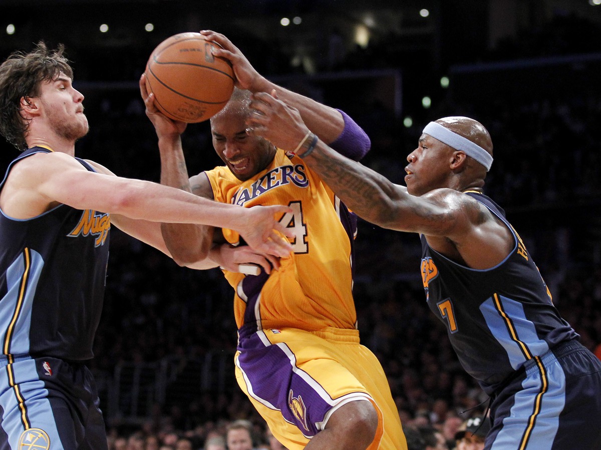 Kobe Bryant sa snaží prejsť cez hráčov Nuggets