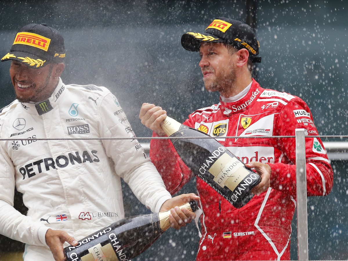 Lewis Hamilton (vľavo) strieka šampanské na Sebastiana Vettela 