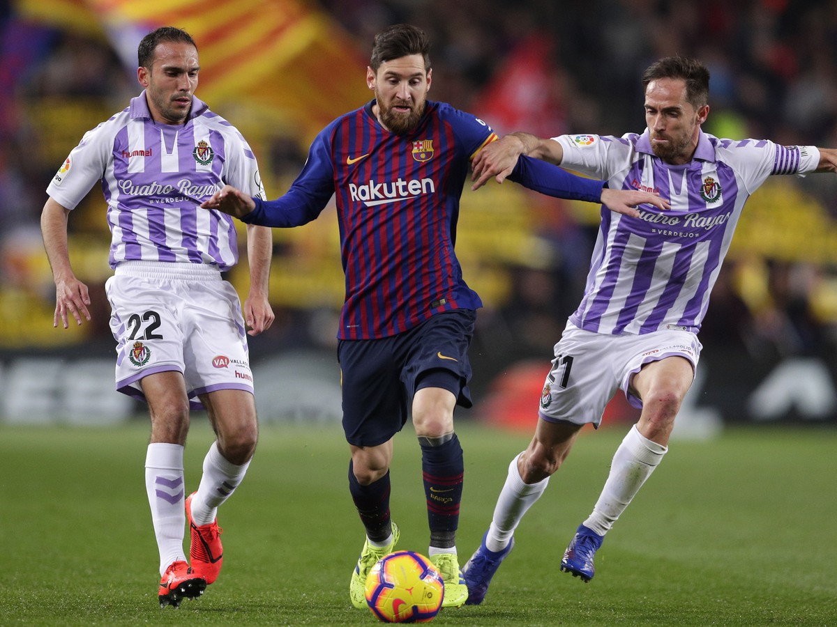 Futbalista FC Barcelony Lionel Messi (uprostred), hráči Valladolidu