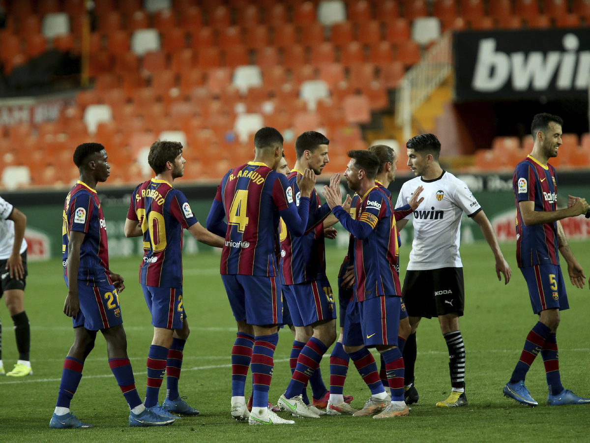 Futbalista Lionel Messi sa teší so spoluhráčmi po výhre 3:2 v zápase proti Valencii