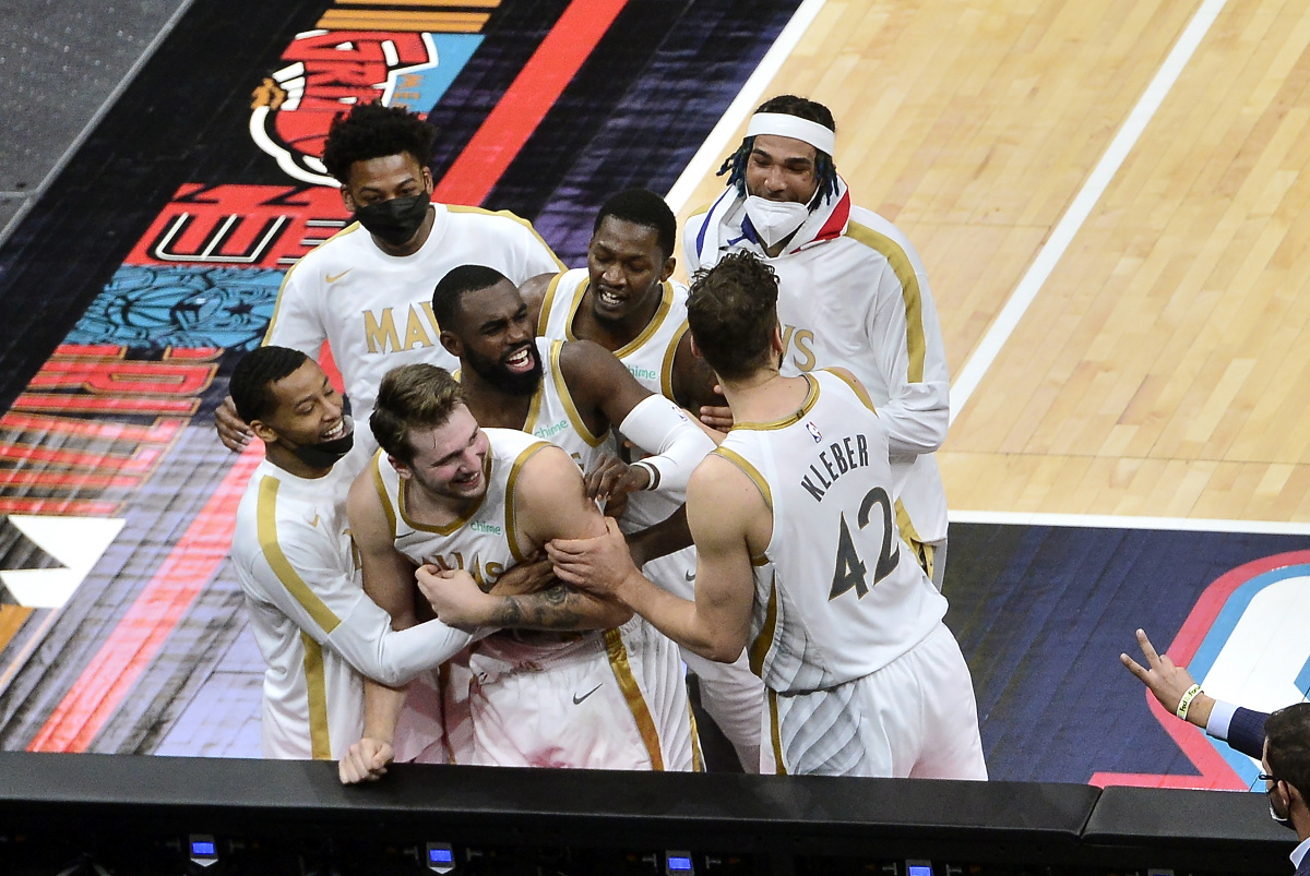 Basketbalista Luka Dončič (uprostred) z Dallasu Mavericks sa teší so spoluhračmi po vhodení víťaznej trojky na konci zápasu 