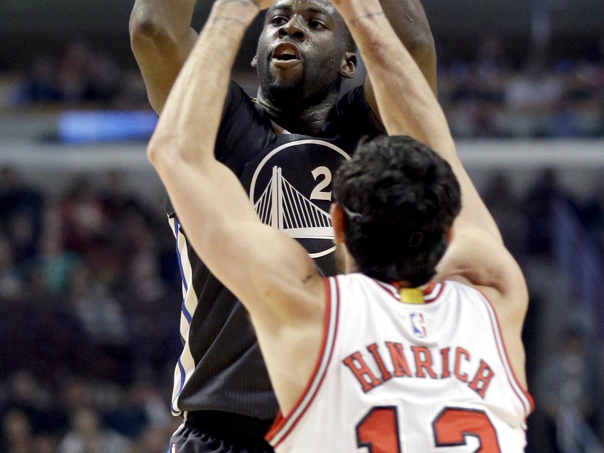 Basketbalista Golden State Warriors Draymond Green (23) strieľa na kôš cez obrancu Chicaga Bulls Kirka Hinricha (12)