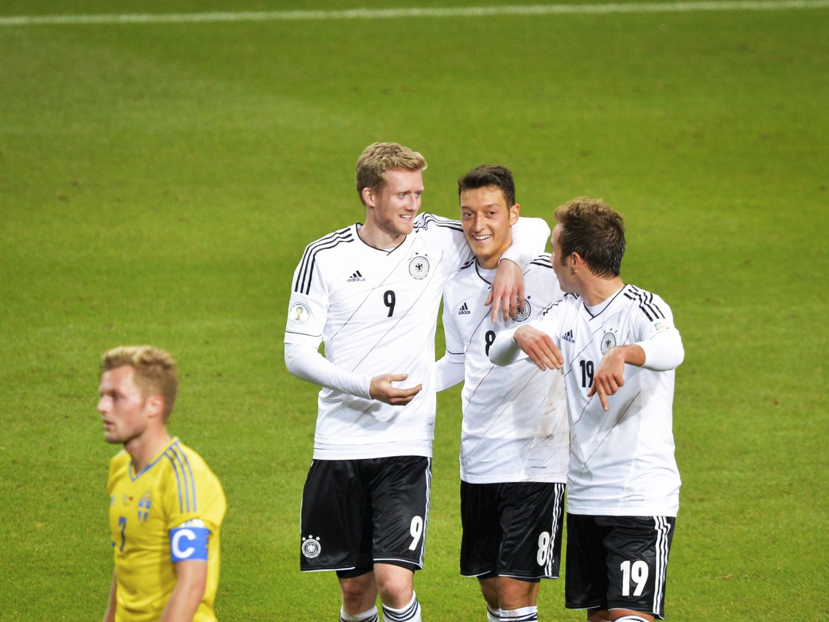 André Schürrle, Mesut Özil a Mario Götze oslavujú gól do siete Švédska