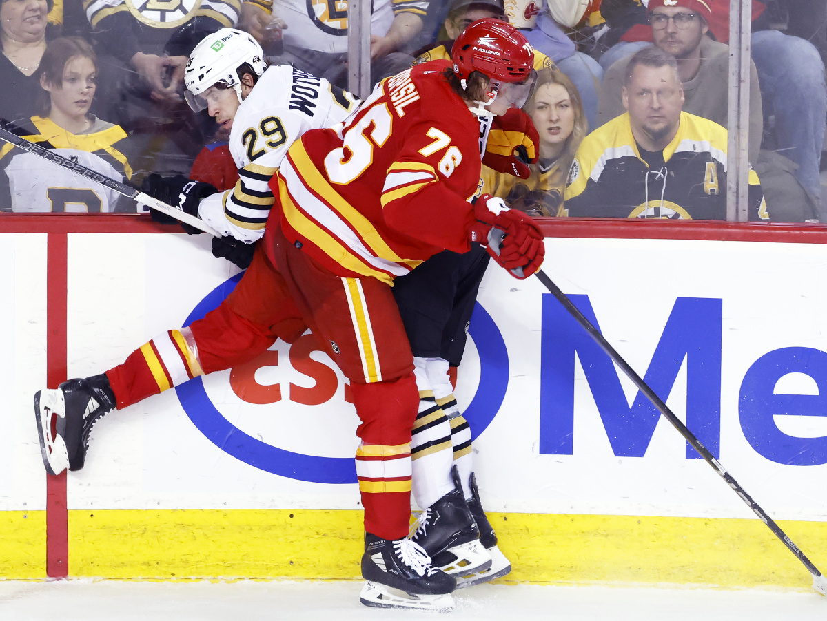 Slovenský útočník Calgary Flames Martin Pospíšil v súboji o puk s Parkerom Wotherspoonom z Bostonu Bruins