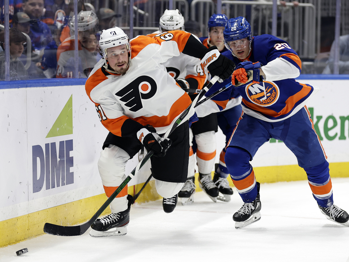 Obranca Philadelphie Flyers Justin Braun (61) a hráč New Yorku Islanders Hudson Fasching bojujú o puk
