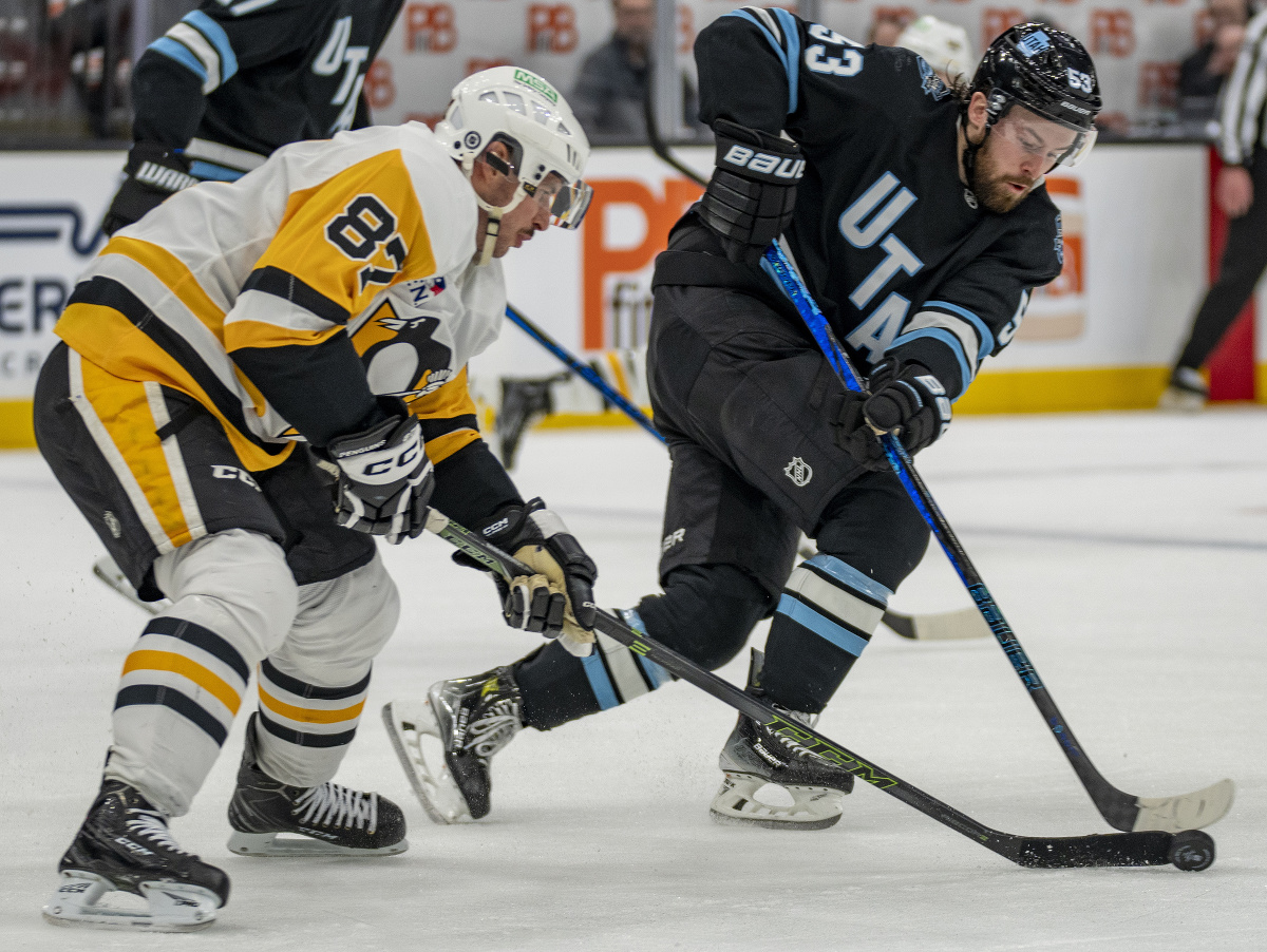 Michael Carcone a Sidney Crosby (87) v súboji o puk