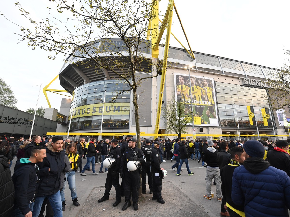 Na snímke nemeckí policajti a fanúšikovia stoja pred Signal Iduna Park v Dortmunde