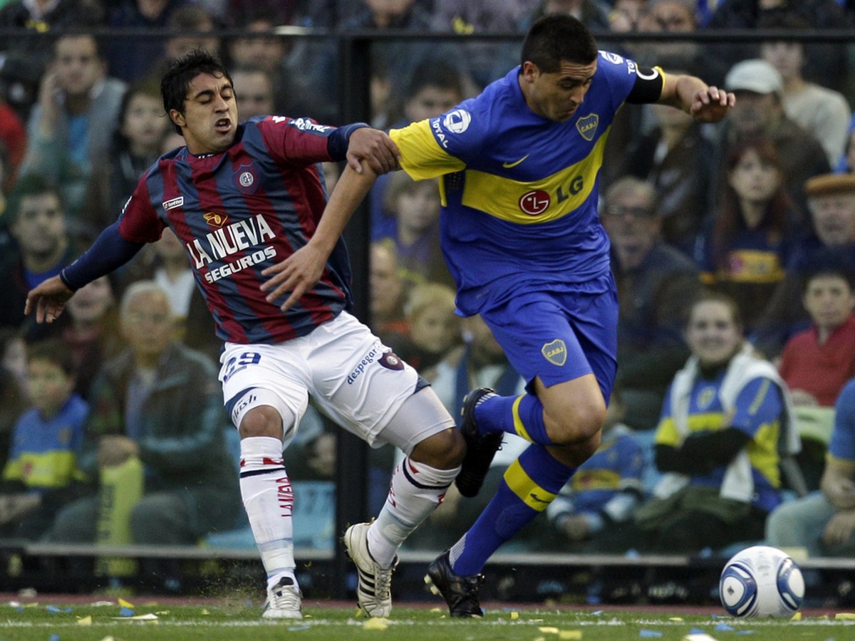 Gabriel Mendez zo San Lorenza (vľavo) v súboji o loptu s Riquelmem z tímu Boca Juniors v zápase argentínskej ligy (28.8.)