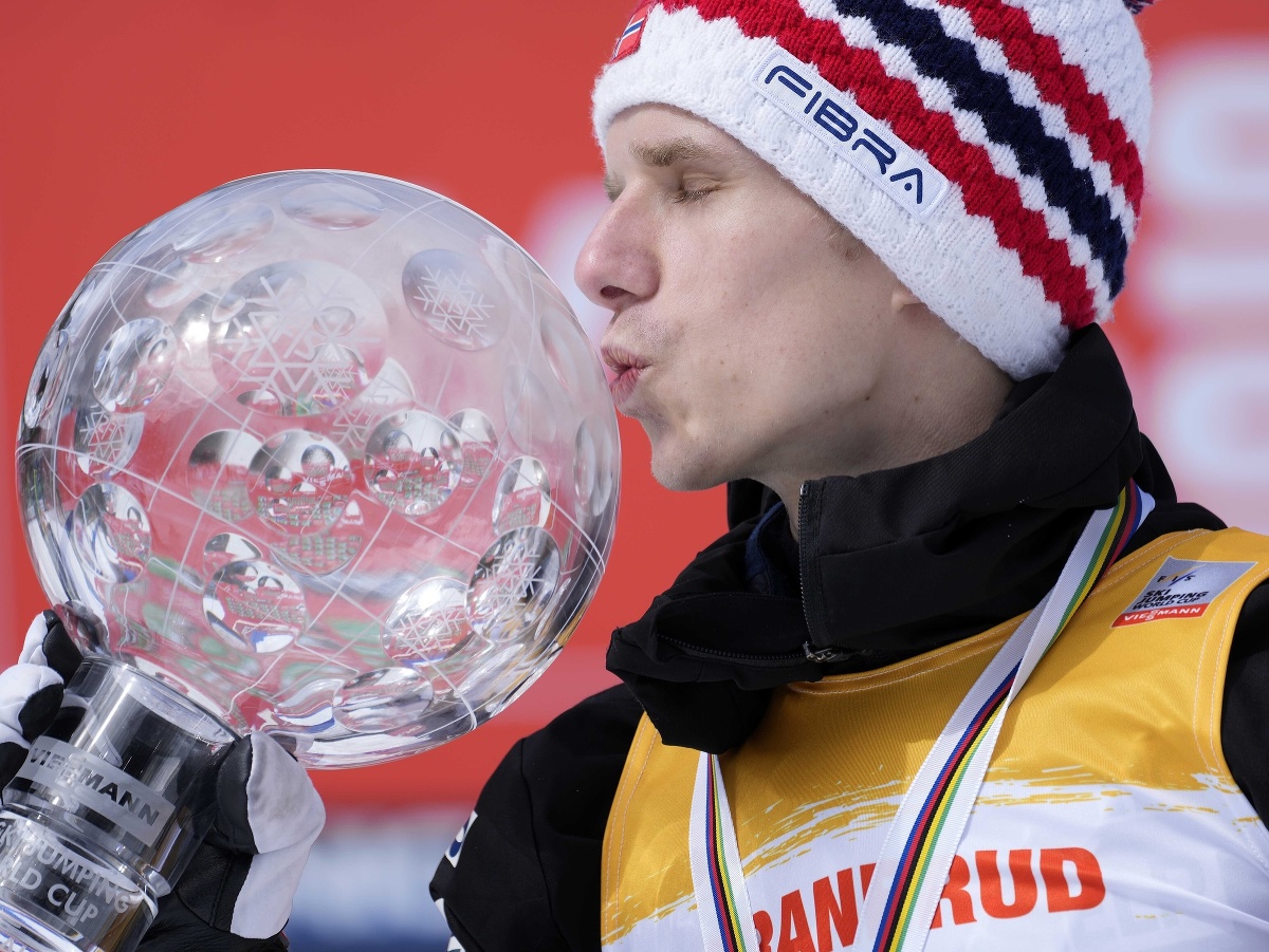 Celkový víťaz Svetového pohára v skoku na lyžiach a víťaz veľkého glóbusu Halvor Egner Granerud z Nórska bozkáva trofej po záverečných letoch v slovinskej Planici