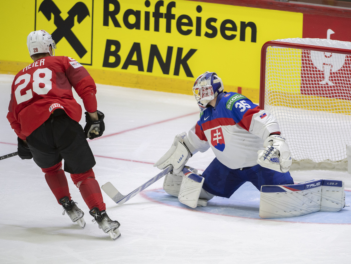 Na snímke vpravo brankár Adam Húska (Slovensko) inkasuje gól a vľavo strelec Timo Meier (Švajčiarsko)
