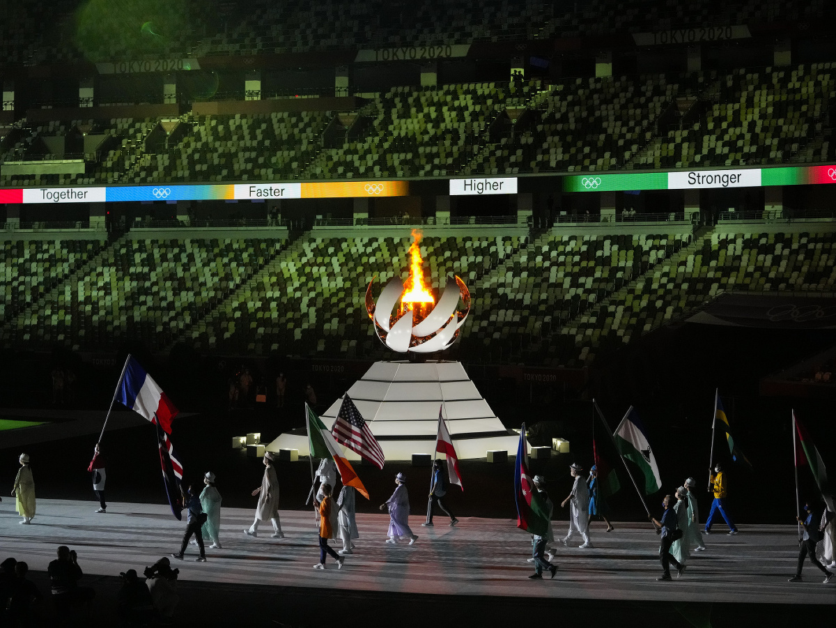 Olympijský oheň a vlajkonosiči so zástavami svojich krajín