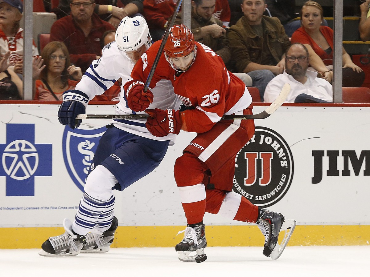 Obranca Toronto Maple Leafs Jake Gardiner (51) a Tomáš Jurčo (Detroit Red Wings, 26) bojujú o puk v druhej tretine zápasu.