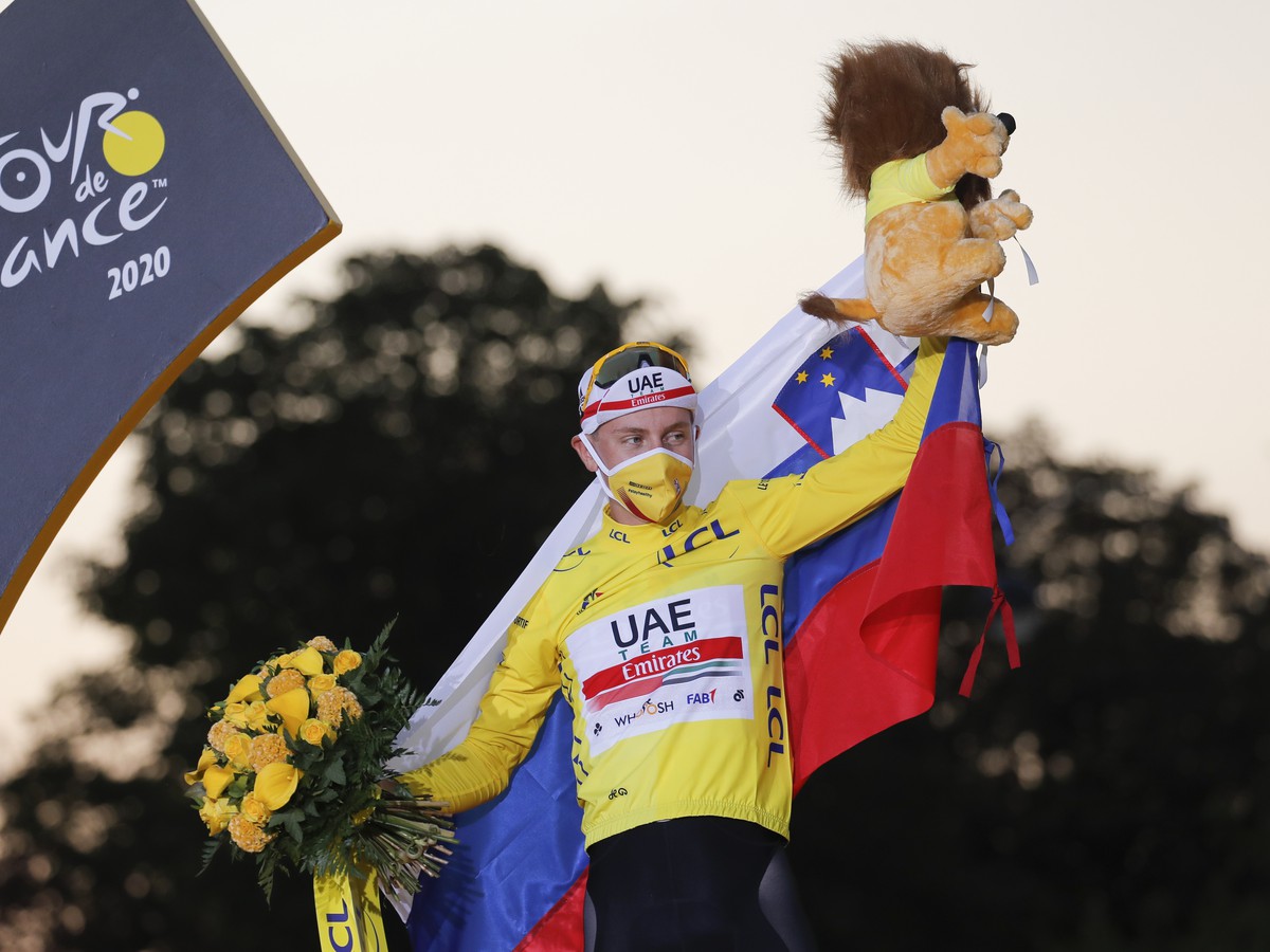 Tadej Pogačar oslavuje na pódiu v žltom drese celkové víťazstvo na Tour de France