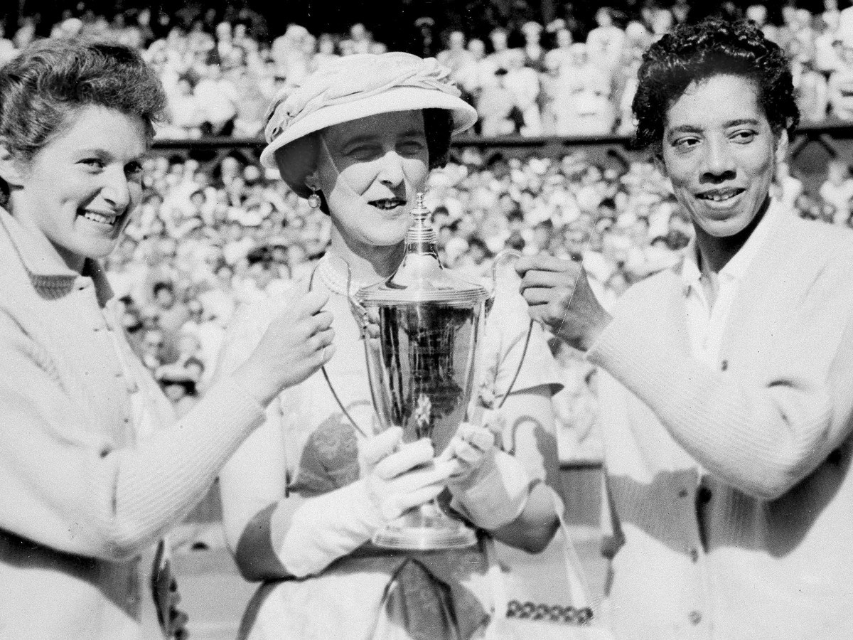 Na archívnej snímke zo 7. júla 1956 vojvodkyňa z Kentu (uprostred) odovzdáva trofej Angele Buxtonovej (vľavo) a Althei Gibsonovej (vpravo), víťazkám ženskej štvorhry na grandslamovom turnaji vo Wimbledone.