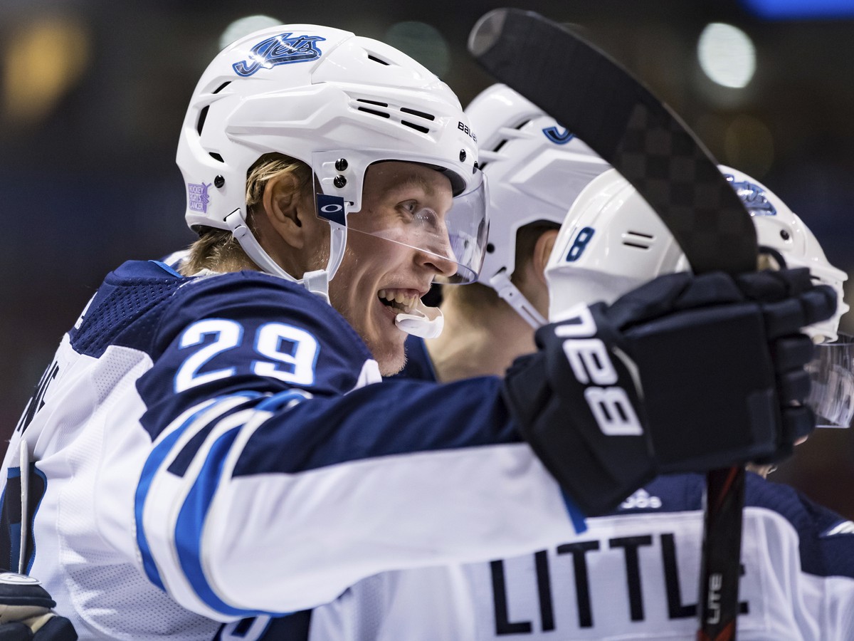 Hokejista Winnipegu Jets Patrik Laine z Fínska sa teší so spoluhráčmi po strelení gólu