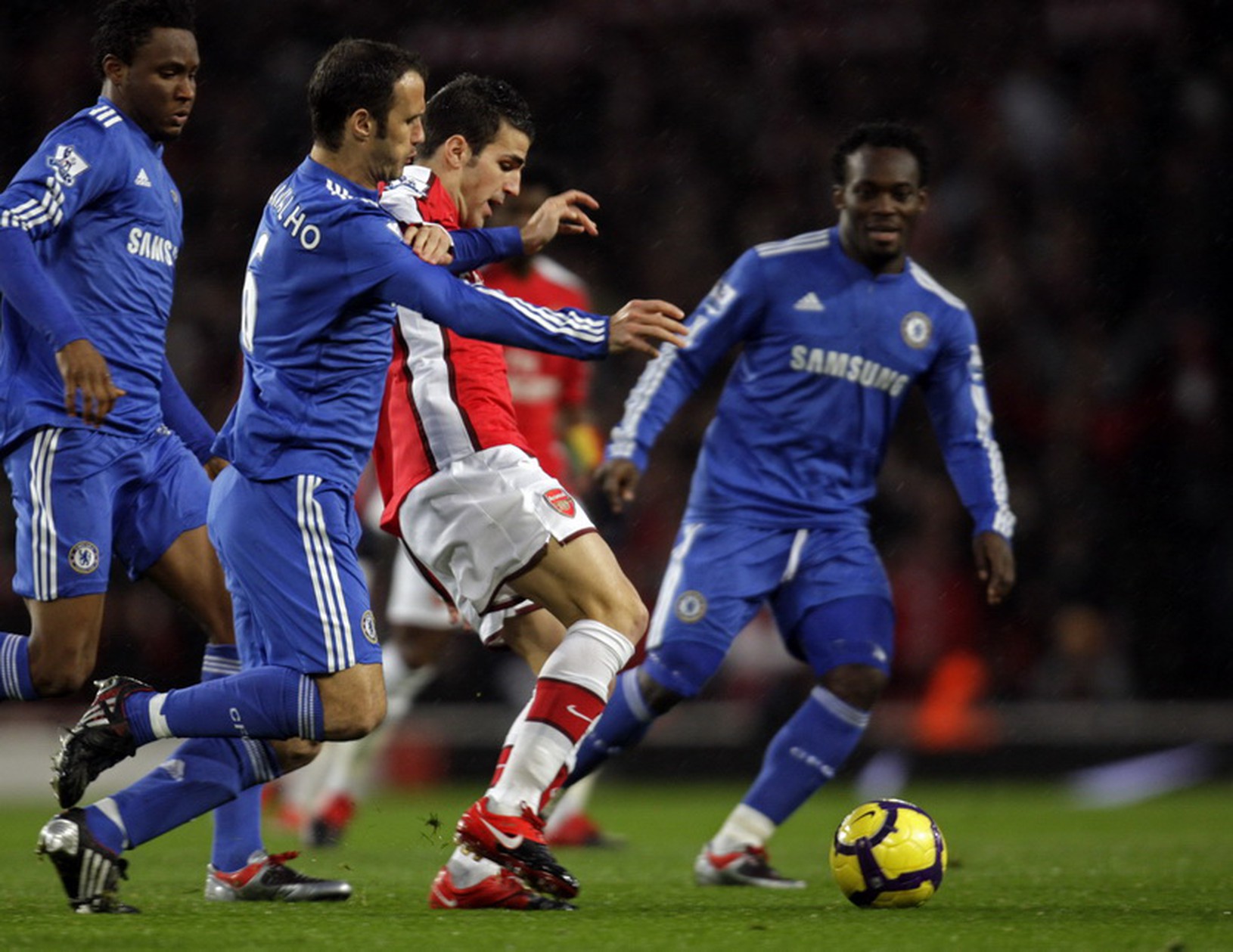 Cesc Fabregas obkľúčený hráčmi