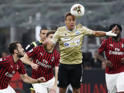 Hráči AC Miláno sledujú protihráča s loptou