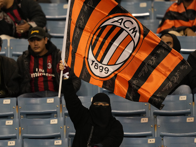Fanúšička drží vlajku AC Milána pred začiatkom finálového zápasu o taliansky Superpohár