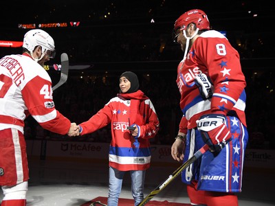 Fatima Al Ali podáva ruku kapitánovi Detroitu Henrikovi Zettenbergovi po čestnom vhadzovaní puku s kapitánom Capitals Alexandrom Ovečkinom 