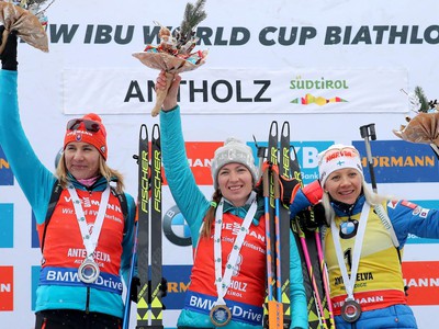 Víťazná bieloruská biatlonistka Darja Domračevová (uprostred) pózuje na pódiu s druhou Slovenkou Anastasiou Kuzminovou (vľavo) a treťou Fínkou Kaisou Mäkäräinenovou (vpravo)