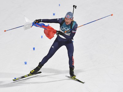 Na snímke slovenská biatlonistka Anastasia Kuzminová drží slovenskú vlajku v cieli po zisku zlatej olympijskej medaily