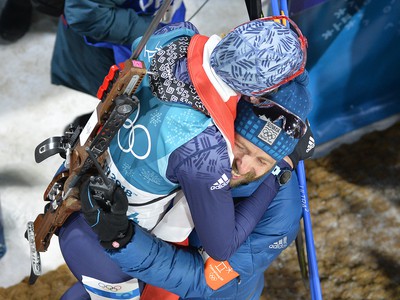 Biatlonistka Anastasia Kuzminová, manžel a tréner Daniel Kuzmin sa tešia po zisku zlatej olympijskej medaily
