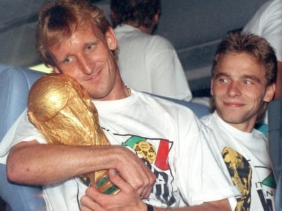 Na archívnej snímke z 9. júla 1990 nemecký futbalový reprezentant Andreas Brehme (vľavo) objíma trofej z MS 1990 v Taliansku