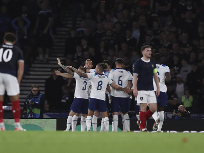 Hráči Anglicka oslavujú gól, v popredí smutní Škóti