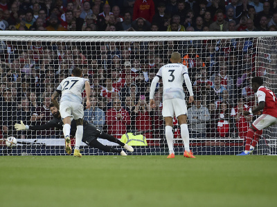 Na snímke vpravo hráč Arsenalu Bukayo Saka strieľa gól z penalty proti Liverpoolu