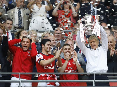 Hráči Arsenalu a tréner Arséne Wenger s trofejou