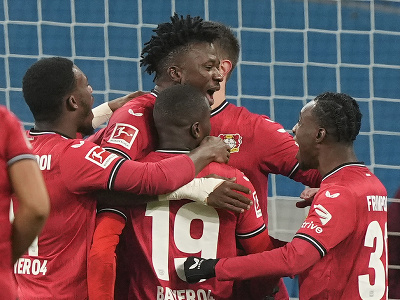 Futbalista Leverkusenu Edmond Tapsoba (uprostred) sa teší z gólu