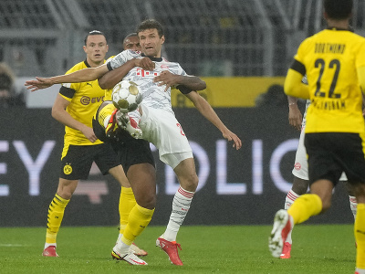 Thomas Müller sa snaží obohrať loptu pred hráčmi Borussie