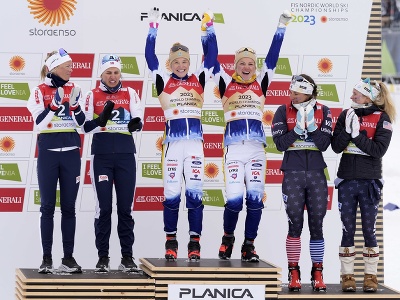 Víťazné švédske bežkyne na lyžiach Emma Ribomová s Jonnou Sundlingovou (uprostred) oslavujú na pódiu so striebornými Nórkami Anne Kjersti Kalvová, Tiril Wengová (vľavo) a bronzovými Američankami Jessie Digginsová, Julia Kernová (vpravo) po tímšprinte na MS v severských lyžiarskych disciplínach v Planici