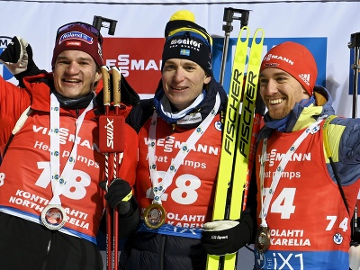 Švédsky biatlonista Martin Ponsiluoma (uprostred) oslavuje na pódiu víťazstvo vytrvalostných pretekov mužov na 20 km v rámci 1. kola Svetového pohára v biatlone 29. novembra 2022 vo fínskom Kontiolahti. Druhý finišoval Švajčiar Niklas Hartweg (vľavo) a tr