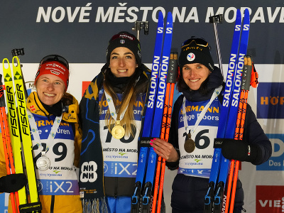 Talianska biatlonistka Lisa Vittozziová (uprostred) sa teší na pódiu po triumfe vo vytrvalostných pretekoch žien na 15 km na majstrovstvách sveta v Novom Meste na Morave v utorok 13. februára 2024. Druhá skončila Nemka Janina Hettichová-Walzová (vľavo).  Bronz si vybojovala Francúzka Julia Simonová, ktorá získala medailu aj vo štvrtom štarte na šampionáte.